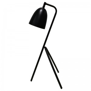 Tre ben -skrivebordslampe med sort finish og en på/off -rocker -switch i kø på værelse