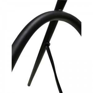 Tre ben -skrivebordslampe med sort finish og en på/off -rocker -switch i kø på værelse